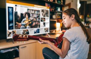 Young girl taking a guitar lesson online