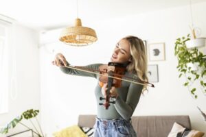 Blonde woman smiling playing the violin