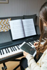 Young woman using an iPad to download sheet music for her piano