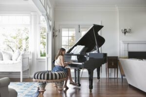 Young girl playing the piano in a sunny room