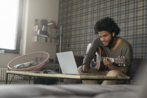 Man playing guitar through an online lesson
