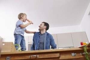 Son singing to his father in their kitchen