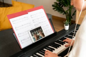 Close up of a woman learning to play the piano using an online app
