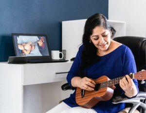 Woman learning to play ukulele online