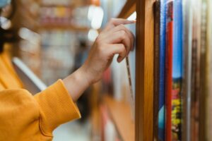 Close up of hand picking a book off the shelf