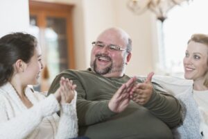 Man sitting on couch talking to his family using ASL