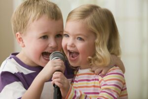 Brother and sister singing into a microphone