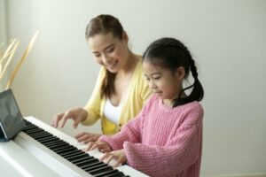 Female piano teacher helping a student learn to play piano