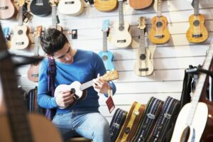 Young man playing ukulele in a music store