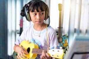 a young girl taking her first ukulele lesson