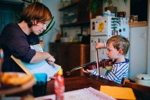 child working with a violin teacher