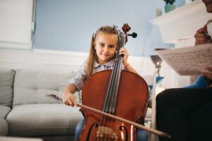 Little girl practicing playing the cello