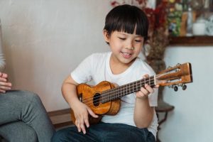 a child learns the names for the ukulele parts