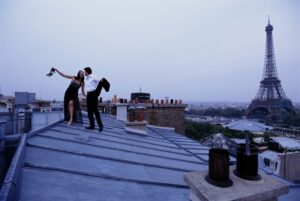 Young couple in formal dress hodling hands on a roof