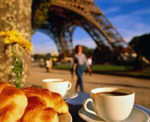 Close up of coffee and a pastry in front of the Eiffel Tower