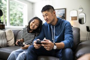 Father and daughter playing video games together