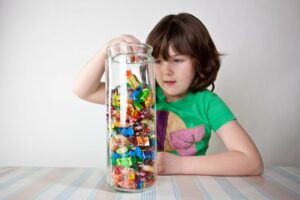 Little girl reaching into a candy jar
