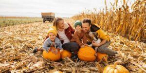 Happy family with cute dog at pumpkin patch