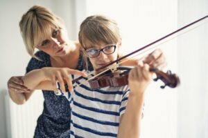 Mom showing daughter how to play violin