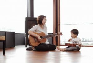 Mother and baby playing guitar