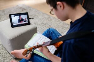 Teen boy taking a virtual guitar class