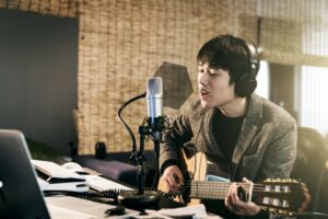 Asian man recording music in his office studio