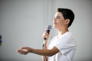 Teen boy singing into microphone