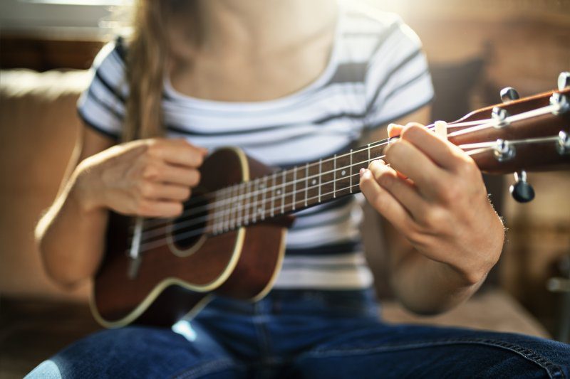 Teenage girl playing a ukulele
