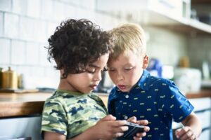 Two boys playing on a cell phone