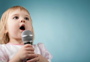 Young child singing into microphone