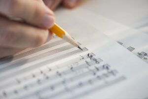 Close up of hand writing sheet music
