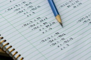 Closeup of algebra problems written in a notebook