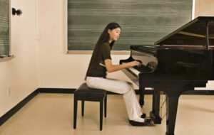 Teen girl learning to play the piano