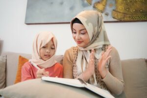 Muslim mother reading with her daughter in their living room