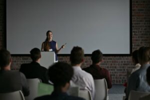 Young woman public speaking in front of a small audience
