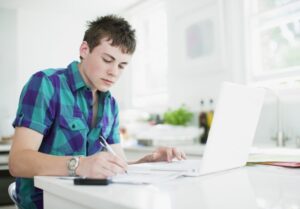 Male student studying on his laptop