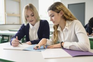 Girl going over a writing assignment with a tutor
