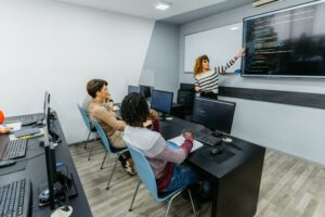 Female programming tutor teaching a class of students to code